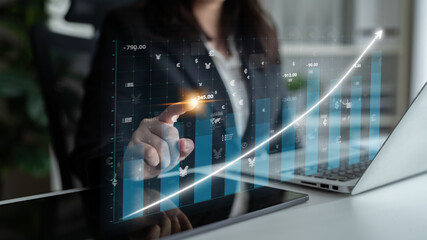 A business professional is interacting with digital financial data, showcasing growth trends and...
