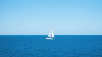 Fototapeta premium A sailboat sails on the blue sea, contrasting with the clear blue sky, fully showing the freedom of marine sports and the tranquil beauty of natural scenery. 