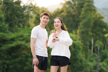 Fototapeta premium Asian couple checking fitness data on smartwatch