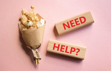 Need Help symbol. Concept word Need Help on wooden blocks. Beautiful pink background with bouquet of flowers. Business and Need Help concept. Copy space