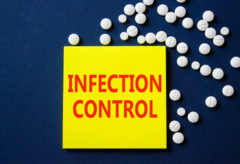 Infection Control symbol. Concept word Infection Control on yellow note. Beautiful deep blue background with pills. Medicine and Infection Control concept. Copy space