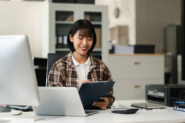 Businesswomen hand working with tablet and laptop computer with documents on office desk in modern office.