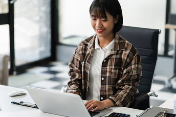 Businesswomen hand working with tablet and laptop computer with documents on office desk in modern office.