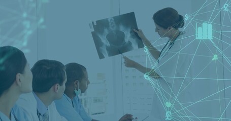 Presenting mature doctor pointing to pelvic X-ray at hospital room, with stethoscopes, copy space