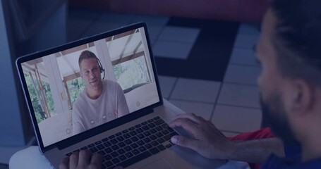 Typing Hispanic man sitting at home showing colleague onscreen, using laptop keyboard and headset