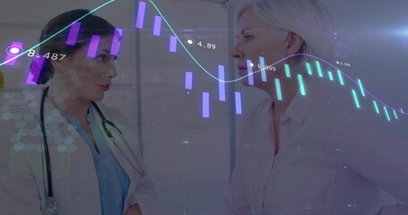 Female physician and mature patient reviewing digital charts in clinic, with stethoscope