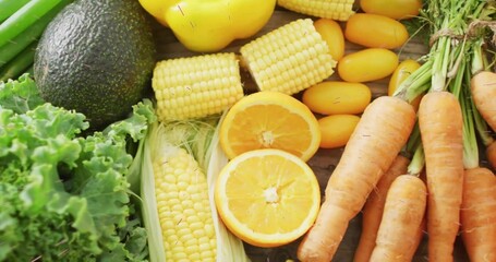 Showcasing fresh produce on kitchen counter, featuring kale, avocado, corn, carrots and oranges © vectorfusionart