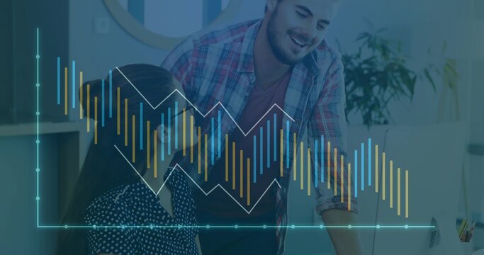 Collaborating colleagues reviewing data on monitor in office, with chart overlay and keyboard