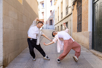 Two dancers performing contemporary street dance in urban alley