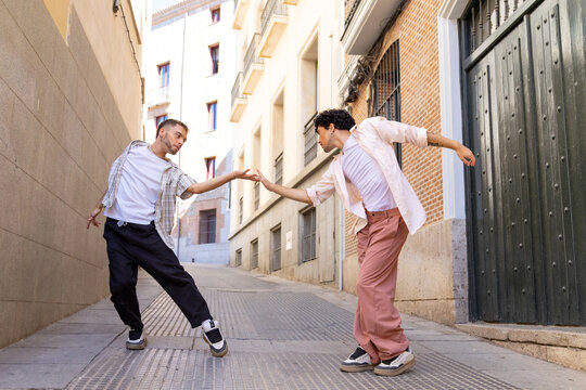 Two men dancing contemporary performance in urban alleyway