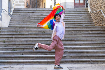 Happy man celebrating lgbtq plus pride with flag