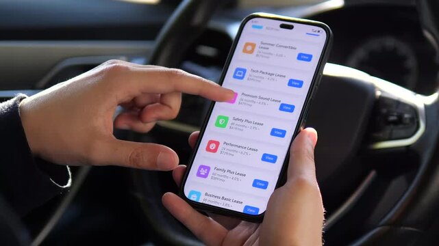 A car shoppers hands scroll through a list of diverse vehicle leasing options on a smartphone, comparing different models and terms available in the market.