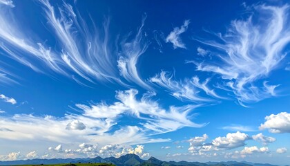Dramatic high altitude cirrus clouds streak across a bright blue sky