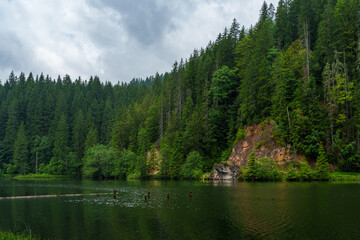 Obraz premium beautiful and dramatic landscape with lake, mountains and forest against a cloudy sky