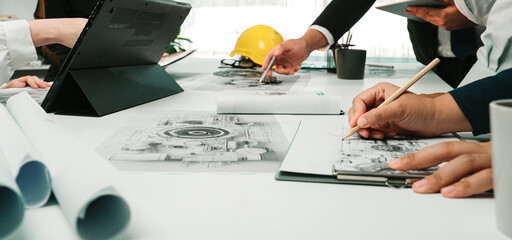 A group of professionals engages in a collaborative meeting, discussing architectural designs and...