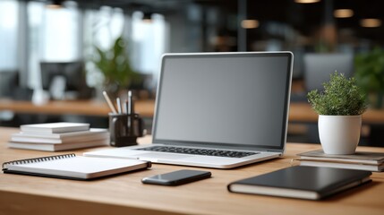 Modern Office Workspace with Laptop, Notebooks, and Smartphone on Wooden Desk in Open Office Environment