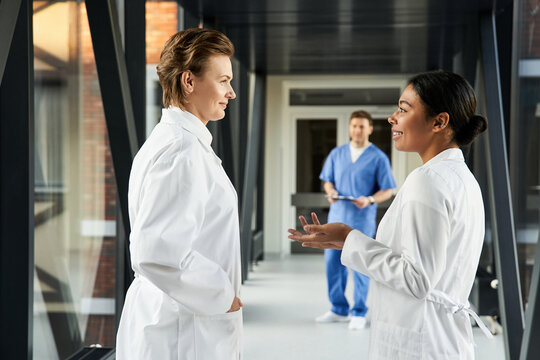 Diverse medical professionals collaborate in a modern hospital corridor - Powered by Adobe