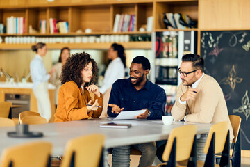 A Woman and Two Men Collaborate During Casual Business Meeting in Modern Kitchen