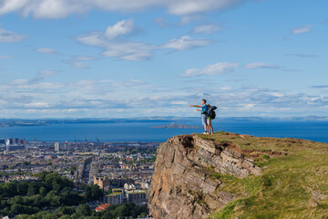 Exploring hikers point horizon on top of Arthurs Seat, Edinburg