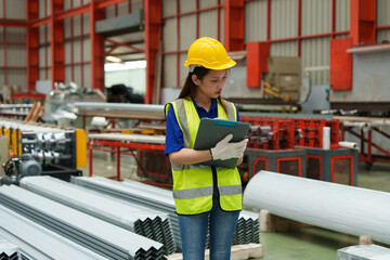 Engineers and staff inspect the production line of components in a metal sheet and metal roofing manufacturing plant.