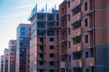 Fototapeta premium Modern residential buildings with brick facades and large windows are being built, showcasing urban planning and architectural innovation in a dynamic urban environment. High quality photo