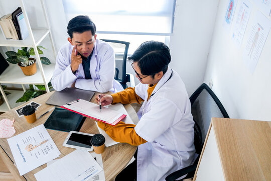 Two Doctors Collaborating on Patient's Chart for Improved Healthcare in Modern Clinic