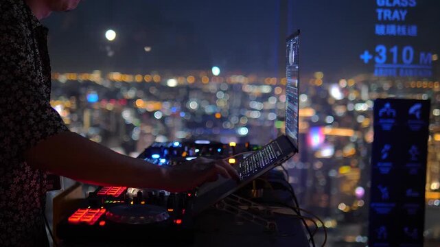 DJ performing on rooftop at 310 meters above Bangkok city &ndash; nightlife and music scene with stunning city lights