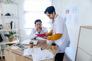 Obraz premium Asian Doctors Reviewing Patient Records in Office Clinic