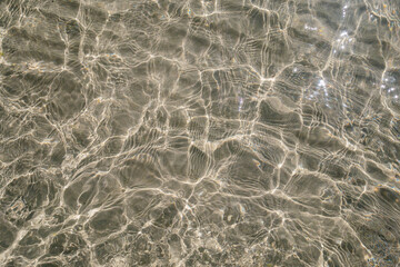 Sunlit water over shallow sandy seabed