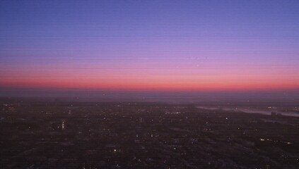 Fototapeta premium Revealing city skyline stretching horizon at dusk, distant water body and scattered city lights
