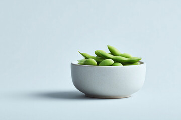Minimalist image featuring a bowl of vibrant green edamame. Perfect for health, wellness, or foodrelated projects. Evokes freshness and simplicity. Clean aesthetic.