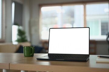 Empty screen laptop computer on table at home office