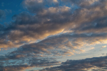 Blurred dark clouds drifting across the sky dome in separate lines against the evening sky background.