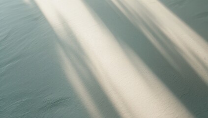 Casting sunlight slats forming diagonal bands on floor in room, creating light and shadow pattern