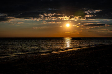 Golden Sunset Over the Calm Ocean with Beach Foreground