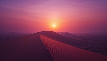 Glowing sand dune ridge under sunlight near horizon at desert sunrise, with distant dunes fading