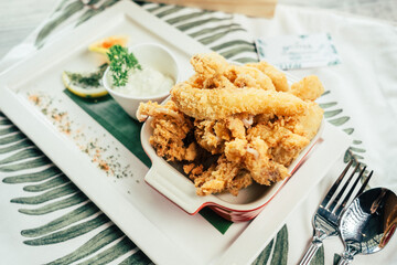 Crispy and delicious fried calamari with dipping sauce, elegantly plated with fresh lemon and parsley