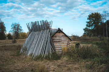 Small mill by stream in field.