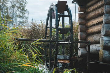 Water mill wheel turning in creek.