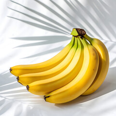 Ripe Yellow Bananas with Palm Leaf Shadows on White Background Keywords: banana, bananas, bunch, fruit, yellow, ripe, food, healthy, organic