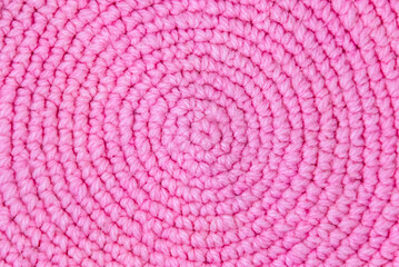 The texture of pink knitted wool fabric. Winter hat background