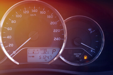 Close up of a red car's fuel level gauge that's nearly empty