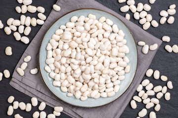 Dry white beans on a plate, top view
