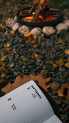 Cozy autumn scene with a campfire, calendar, and fall foliage in September