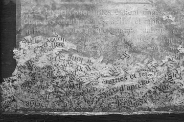 Close-up of weathered and partially erased text on a glass surface, framed by chipped dark wood. The faded black letters on a cloudy white background evoke age, decay, and forgotten information.