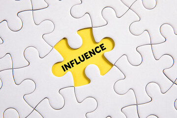 Fototapeta premium The word influence on a missing puzzle piece