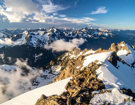 Aerial view of snow-capped mountains under a dynamic cloudy sky