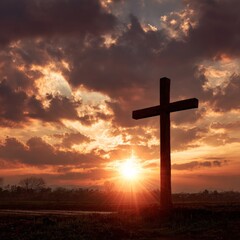 Sunset lighting up the sky behind a large wooden cross in a serene landscape