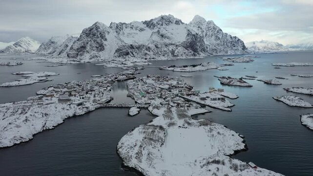 Aerial view of Henningsv&aelig;r's stark beauty with snow-dusted islands contrasting against the dark, cold water, Henningsv&aelig;r, Nordland, Norway.