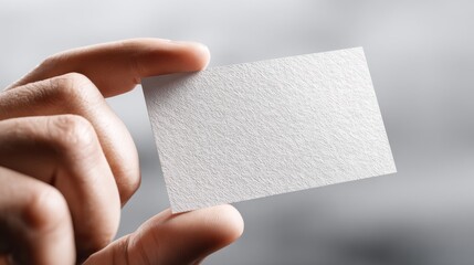 A close-up of a hand holding a blank card, suggesting space for customization and creativity.